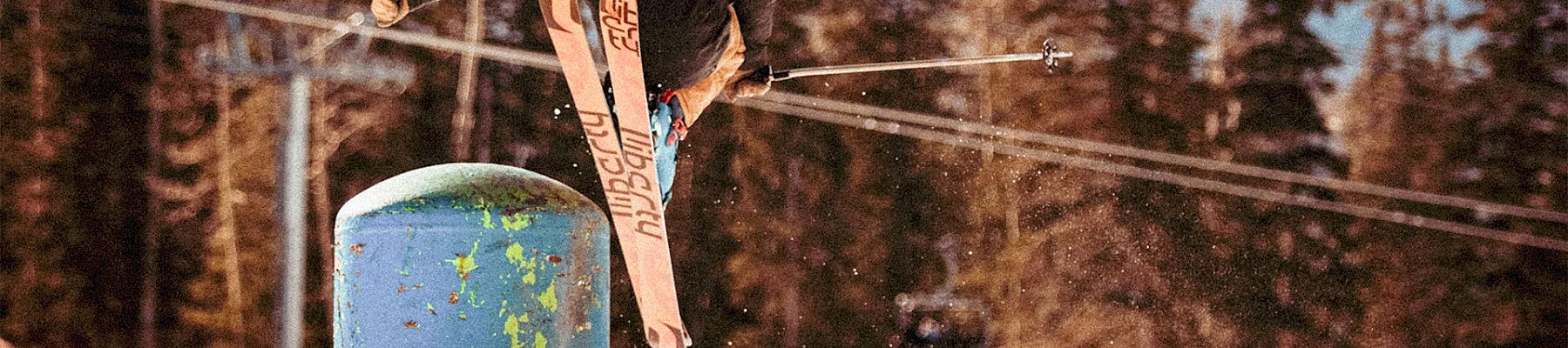 a person jumping off a snow covered hill with skis