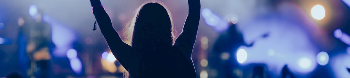 a woman with her hands up in front of a crowd of people